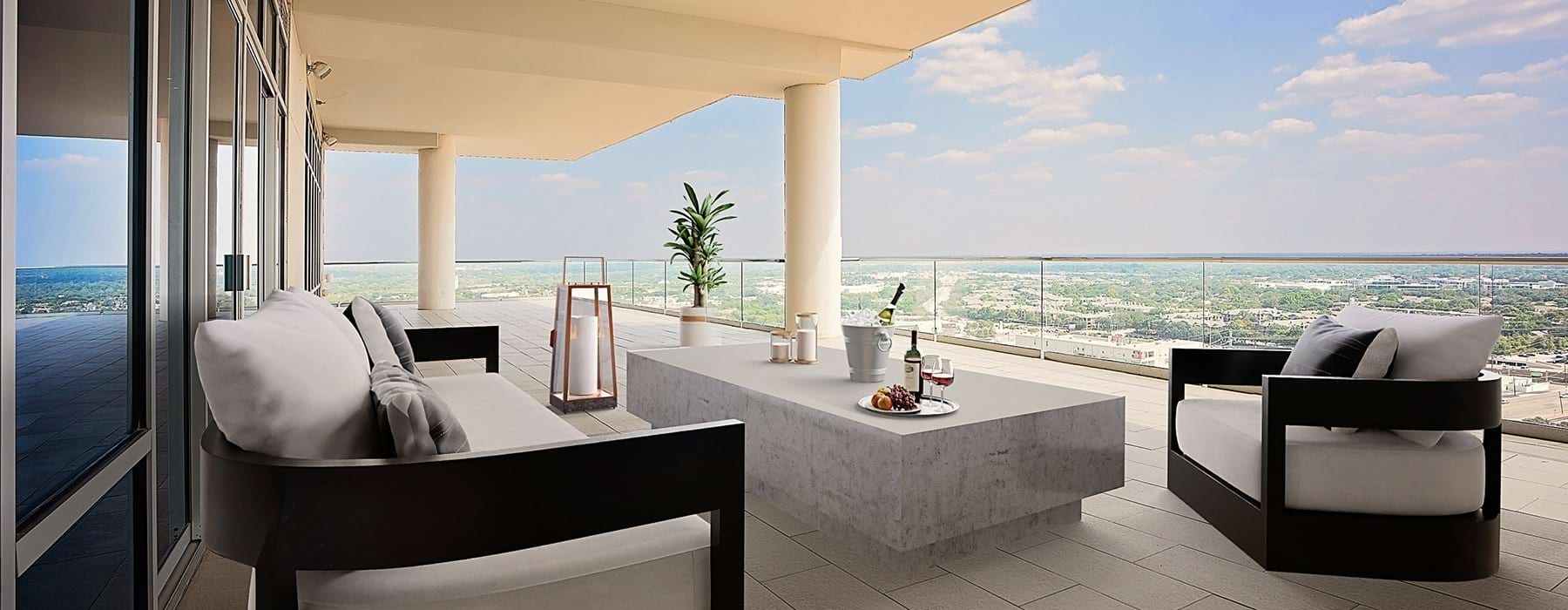 couch and coffee table on a balcony overlooking a city